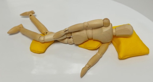 多目的枕の使用例。脇腹と膝をサポートする使い方。横臥位時の姿勢が安定し、首と肩にかかる負荷を軽減できます。